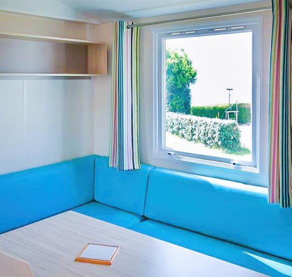 Camping Ambon Coin repas avec 1 banquette. Location mobil home au camping 2 étoiles de Cromenac'h à Ambon, camping accès direct plage proche du Golfe du Morbihan, de la presqu'île de Rhuys 